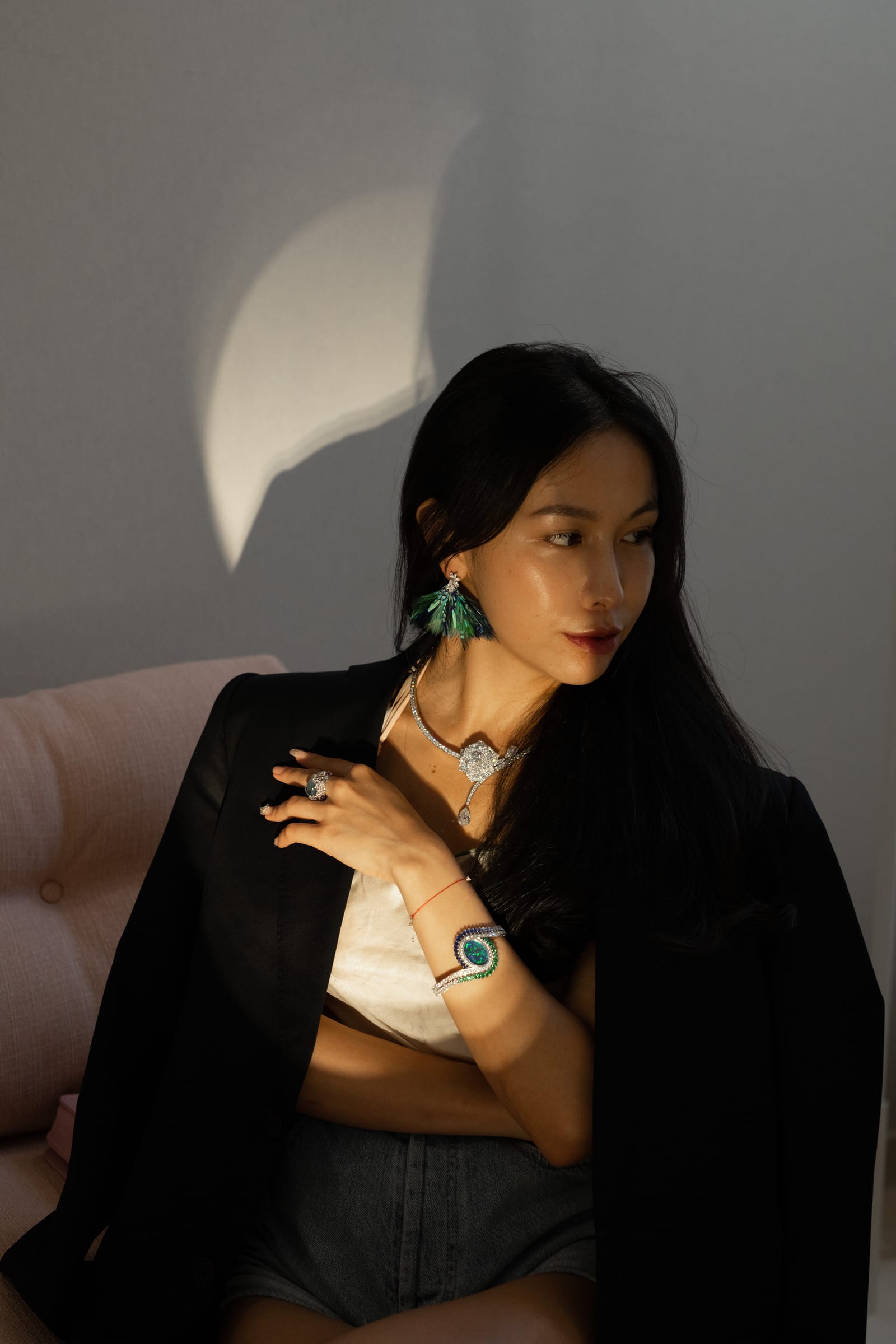 Chelsea wearing a statement necklace and earrings with a black jacket